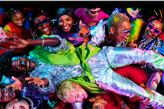 MacBook Pro con la pantalla a todo color que muestra a una persona persona llevada en volandas en una fiesta, destaca la nitidez de la pantalla Liquid Retina XDR