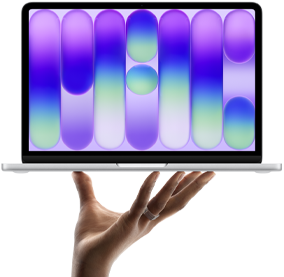 MacBook Neo en plata, portátil sobre las puntas de los dedos de una mano abierta, diseño abstracto a todo color en la pantalla