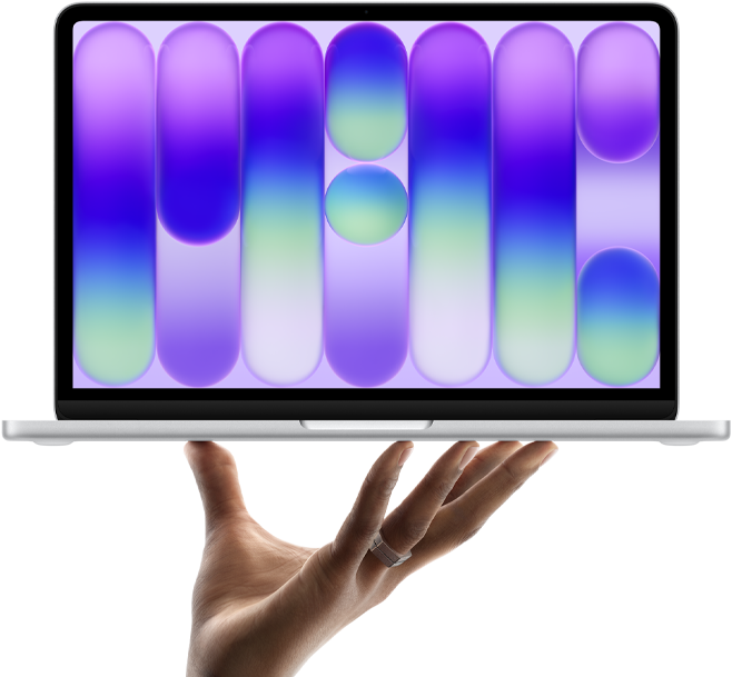 MacBook Neo en plata, portátil sobre las puntas de los dedos de una mano abierta, diseño abstracto a todo color en la pantalla